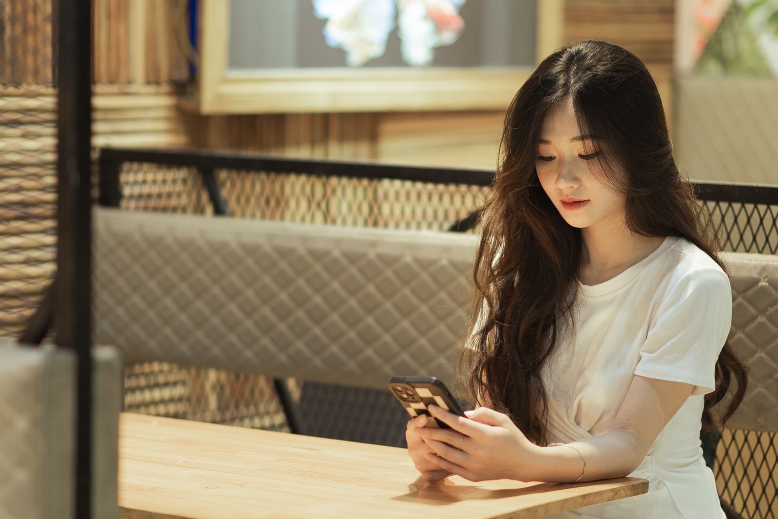 Khách ngồi trong quán xem điện thoại