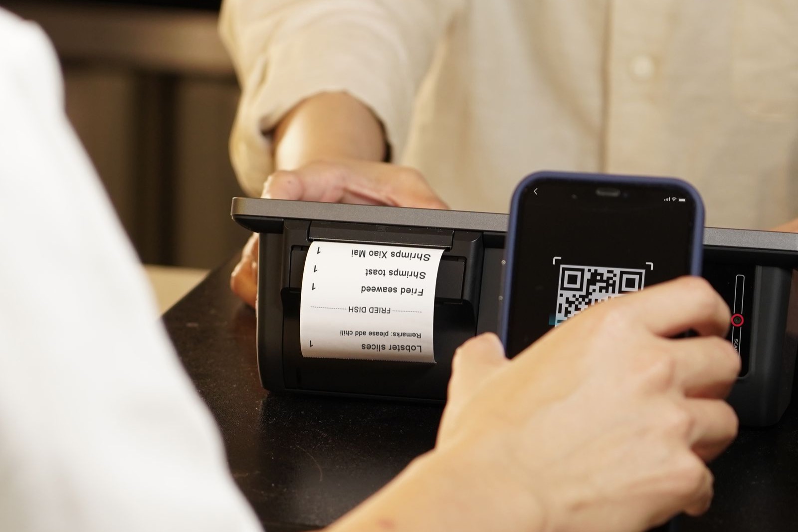 Khách quét mã QR bằng điện thoại tại quầy
