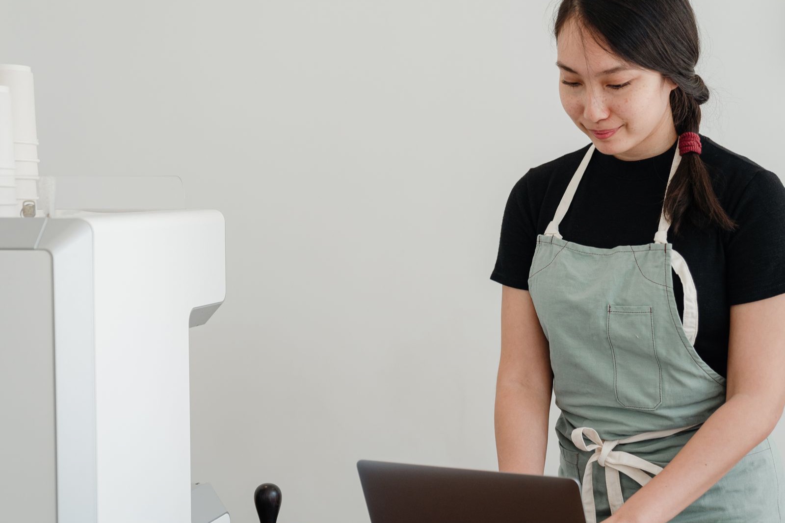 Chủ quán xem số liệu trên laptop trong quán